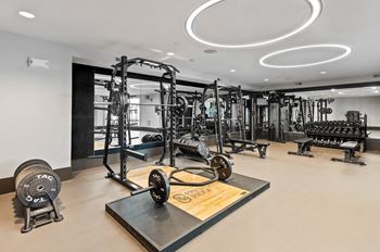 A gym with a variety of equipment including weights and machines.